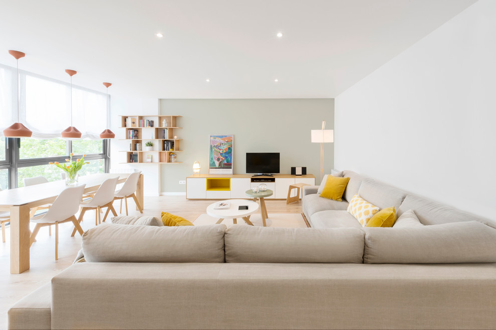 This is an example of a mid-sized scandinavian open concept living room in Barcelona with white walls, light hardwood floors, no fireplace, a built-in media wall and a library.