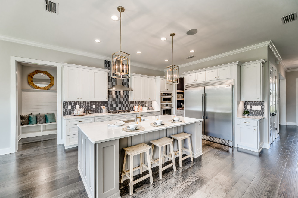 Inspiration for a mid-sized country l-shaped open plan kitchen in Jacksonville with an undermount sink, shaker cabinets, white cabinets, quartz benchtops, blue splashback, porcelain splashback, stainless steel appliances, medium hardwood floors, with island, brown floor and white benchtop.