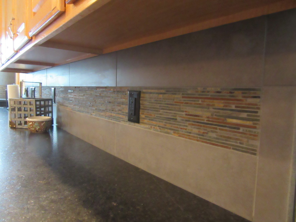 Inspiration for a transitional u-shaped light wood floor eat-in kitchen remodel with an undermount sink, raised-panel cabinets, medium tone wood cabinets, granite countertops, gray backsplash, ceramic backsplash, black appliances and two islands
