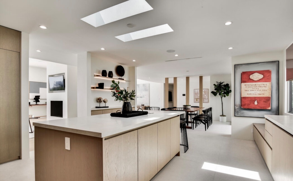 Large contemporary u-shaped eat-in kitchen in Los Angeles with flat-panel cabinets, light wood cabinets, quartz benchtops, with island, white benchtop, white splashback, engineered quartz splashback, panelled appliances, an undermount sink, porcelain floors and grey floor.