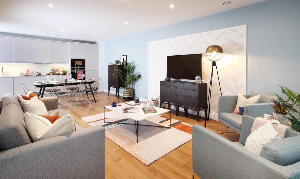 Mid-sized modern loft-style living room in London with a music area, blue walls, light hardwood floors, no fireplace, no tv and brown floor.