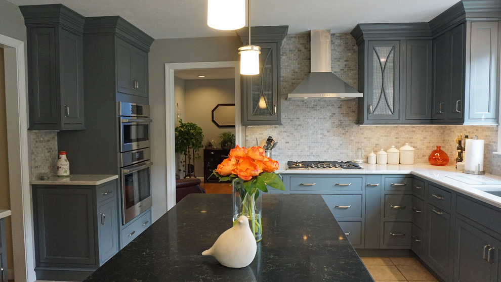 This is an example of a mid-sized transitional l-shaped eat-in kitchen in Boston with a single-bowl sink, beaded inset cabinets, grey cabinets, quartz benchtops, beige splashback, stone tile splashback, stainless steel appliances, ceramic floors and with island.