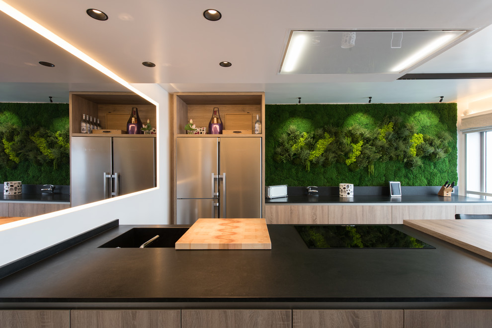 Inspiration for a mid-sized contemporary galley eat-in kitchen in Paris with an integrated sink, beaded inset cabinets, light wood cabinets, granite benchtops, green splashback, stainless steel appliances, ceramic floors, with island, black floor and black benchtop.