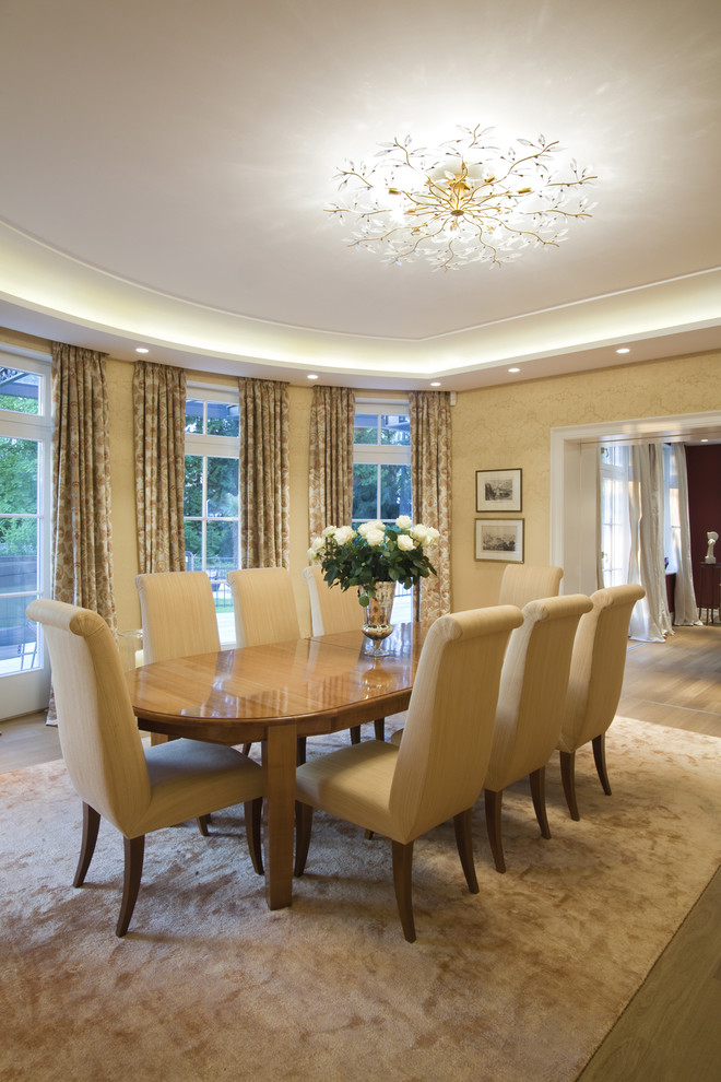 Large traditional open plan dining in Cologne with beige walls and medium hardwood floors.