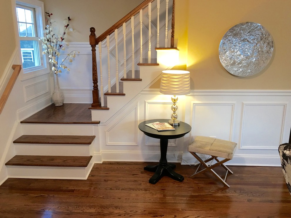 Photo of a mid-sized transitional entry hall in New York with beige walls, medium hardwood floors, a single front door and a dark wood front door.