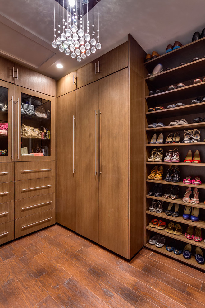 This is an example of a contemporary gender-neutral walk-in wardrobe in Miami with medium wood cabinets, dark hardwood floors, flat-panel cabinets and brown floor.