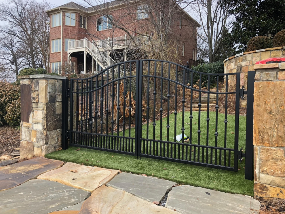 This is an example of a large traditional full sun front yard stone and vinyl fence gate in Nashville.