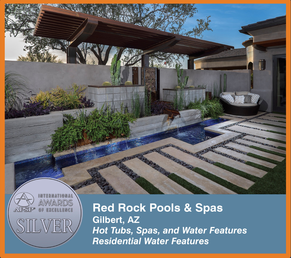 Design ideas for a midcentury backyard custom-shaped pool in Phoenix with a water feature.