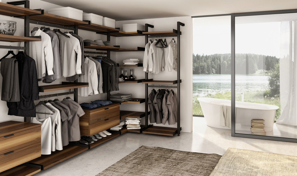 This is an example of a large modern gender-neutral dressing room in Vancouver with flat-panel cabinets, medium wood cabinets and concrete floors.