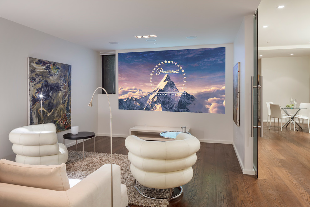 Mid-sized contemporary enclosed home theatre in San Francisco with white walls, medium hardwood floors, a projector screen and beige floor.