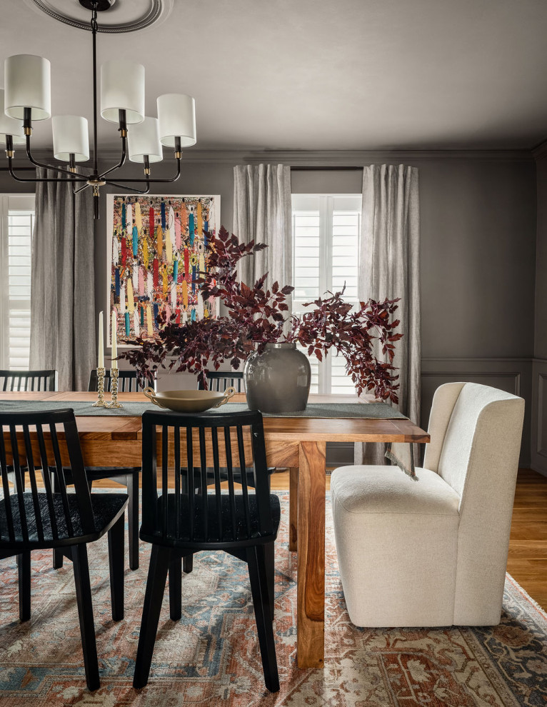Example of a mid-sized transitional medium tone wood floor, brown floor and wainscoting kitchen/dining room combo design in DC Metro with gray walls