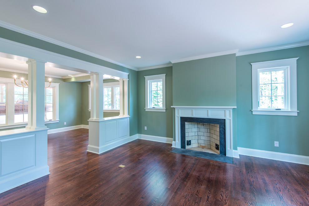 Photo of a mid-sized traditional open concept living room in Other with dark hardwood floors, green walls, a standard fireplace and a wood fireplace surround.