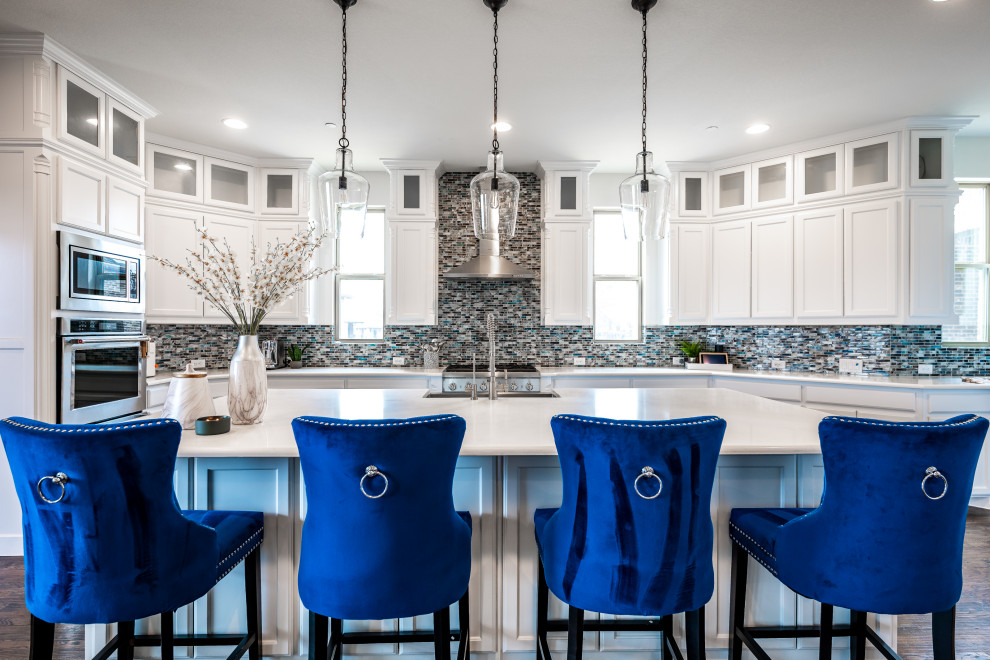 Inspiration for a large transitional eat-in kitchen in Dallas with a single-bowl sink, louvered cabinets, white cabinets, quartzite benchtops, blue splashback, glass tile splashback, stainless steel appliances, dark hardwood floors, with island, brown floor and white benchtop.