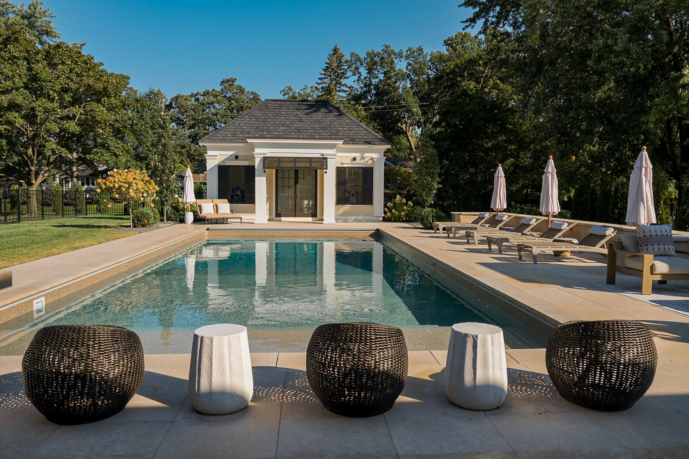 Inspiration for a large nautical back rectangular lengths swimming pool in Minneapolis with a pool house and natural stone paving.