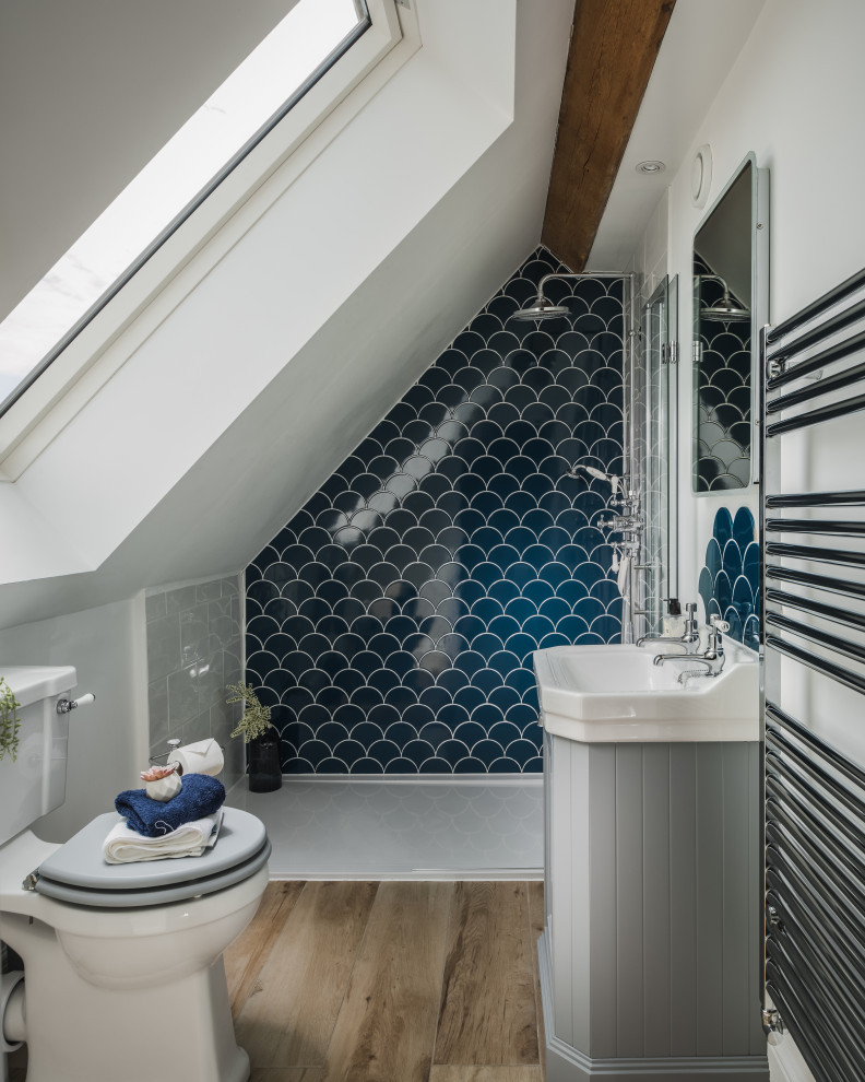 Пример оригинального дизайна: ванная комната в стиле кантри с серыми фасадами, синей плиткой, белыми стенами, светлым паркетным полом, душевой кабиной, консольной раковиной, бежевым полом, открытым душем, тумбой под одну раковину, встроенной тумбой и сводчатым потолком