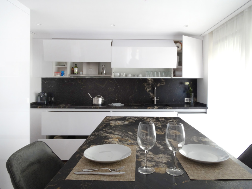 Esempio di una cucina minimal di medie dimensioni con lavello sottopiano, ante lisce, top in marmo, paraspruzzi nero, paraspruzzi in marmo, pavimento in legno massello medio, pavimento marrone e top nero