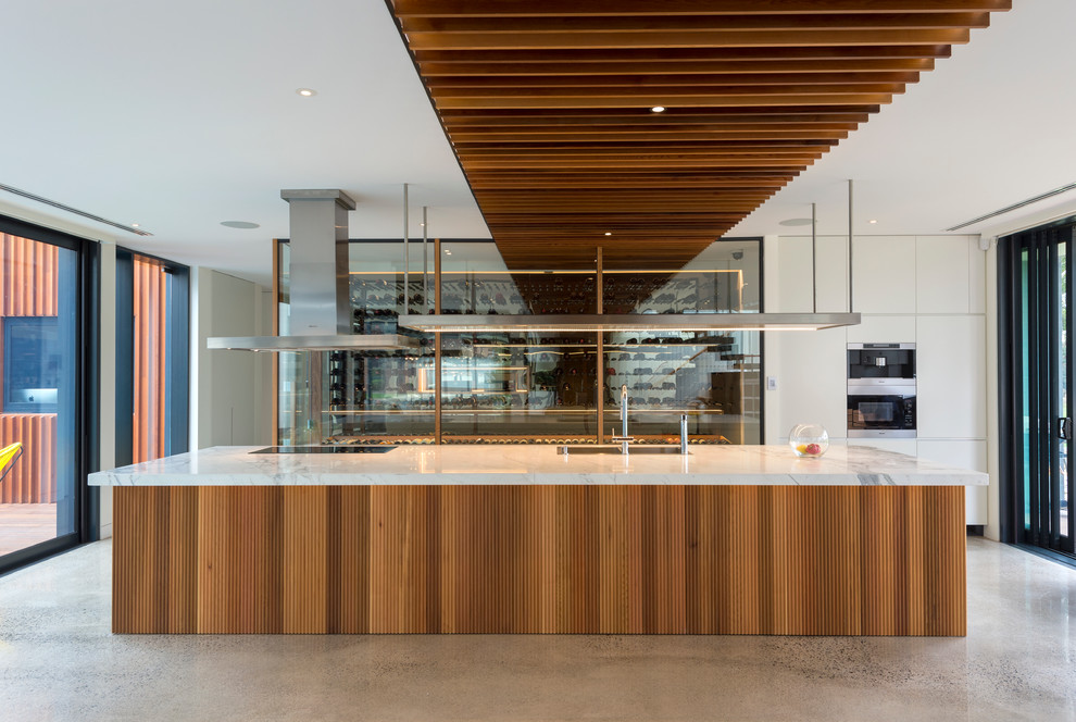 Large contemporary kitchen in Melbourne with concrete floors and with island.