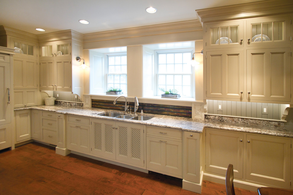 Photo of a large traditional galley eat-in kitchen in Philadelphia with a triple-bowl sink, recessed-panel cabinets, white cabinets, granite benchtops, stainless steel appliances, medium hardwood floors, no island and multi-coloured splashback.