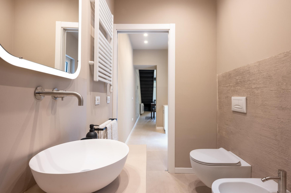 Aménagement d'un WC suspendu industriel de taille moyenne avec des portes de placard beiges, un mur beige, un sol en carrelage de porcelaine, une vasque, un sol beige, un plan de toilette beige, meuble-lavabo suspendu et un plafond décaissé.