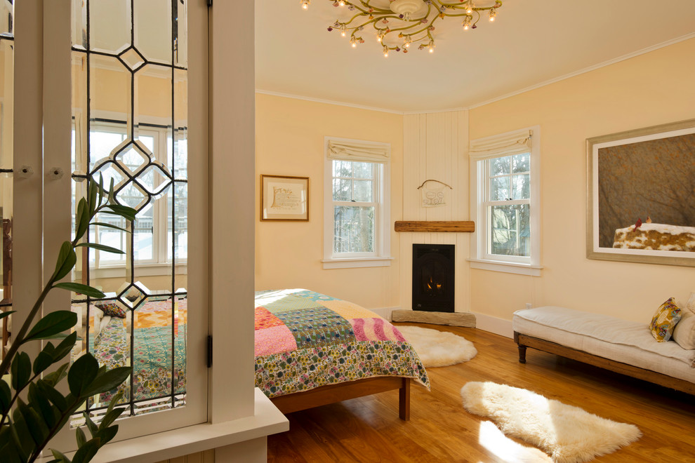 Photo of a country bedroom in New York with a corner fireplace.