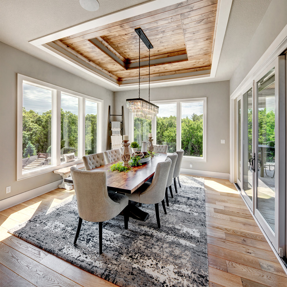 Country dining room in Dallas with grey walls, beige floor and medium hardwood floors.