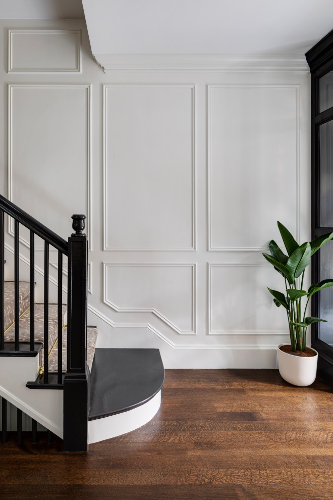 Mid-sized transitional porcelain tile, white floor, wallpaper ceiling and wainscoting foyer photo in Boston with black walls and a black front door