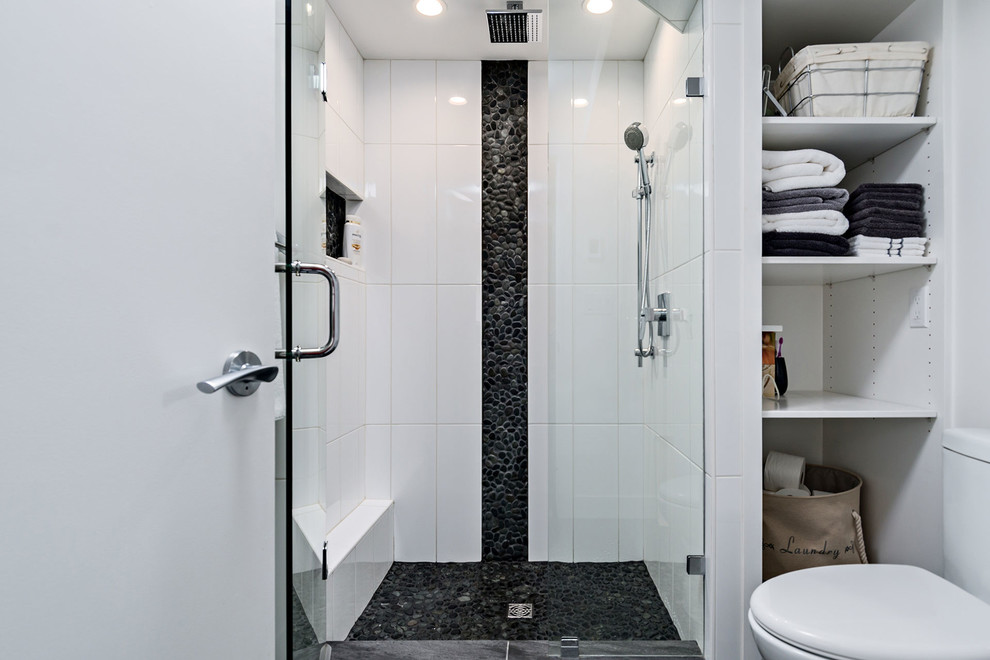 This is an example of a small contemporary 3/4 bathroom in Vancouver with open cabinets, white cabinets, an alcove shower, a two-piece toilet, white tile, pebble tile and white walls.