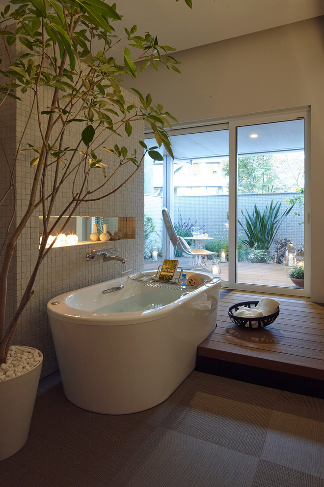Design ideas for an asian bathroom in Tokyo with a freestanding tub and gray tile.