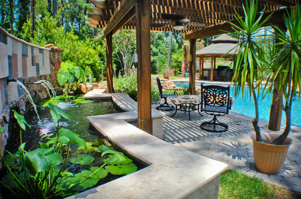 Inspiration for a mid-sized mediterranean backyard deck in Houston with a water feature and a pergola.
