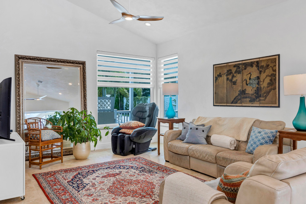 Mittelgroßes, Offenes Maritimes Wohnzimmer mit weißer Wandfarbe, Travertin, beigem Boden und gewölbter Decke in Tampa