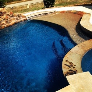 Large beach style backyard custom-shaped lap pool in Houston with a hot tub and natural stone pavers.