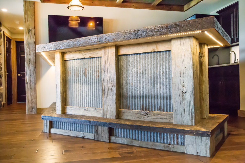 Example of a large mountain style walk-out medium tone wood floor home design design with white walls, a standard fireplace and a stone fireplace