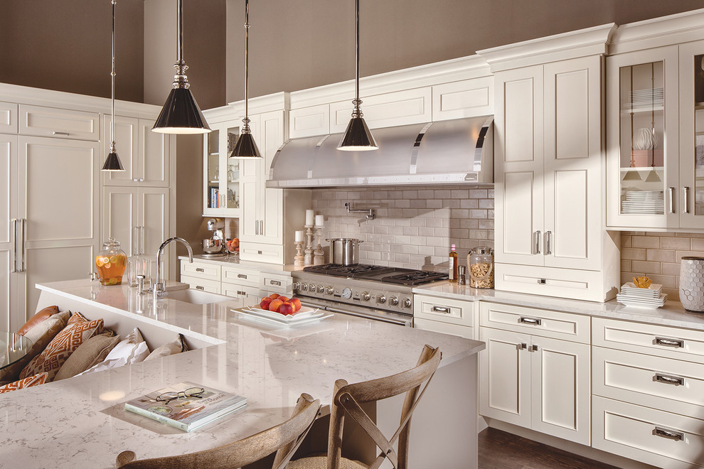 Large transitional l-shaped dark wood floor and brown floor eat-in kitchen photo in Minneapolis with a farmhouse sink, flat-panel cabinets, white cabinets, quartzite countertops, white backsplash, subway tile backsplash, stainless steel appliances, an island and white countertops