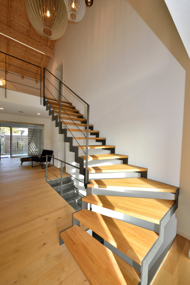 Идея дизайна: изогнутая лестница среднего размера в стиле лофт с деревянными ступенями
