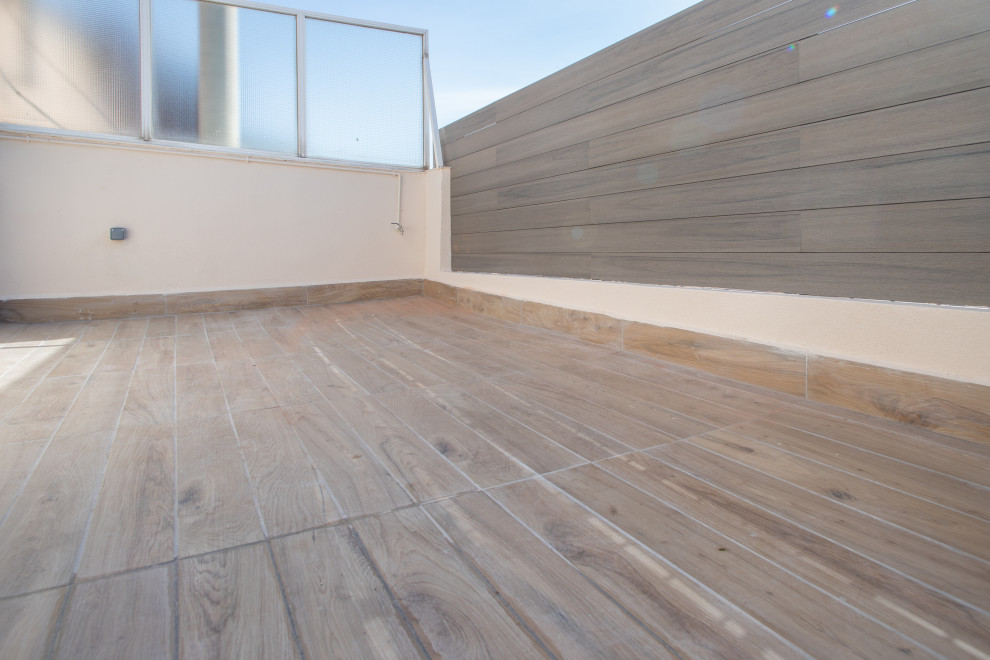Inspiration for a large mediterranean rooftop and rooftop deck in Barcelona with with skirting, no cover and wood railing.
