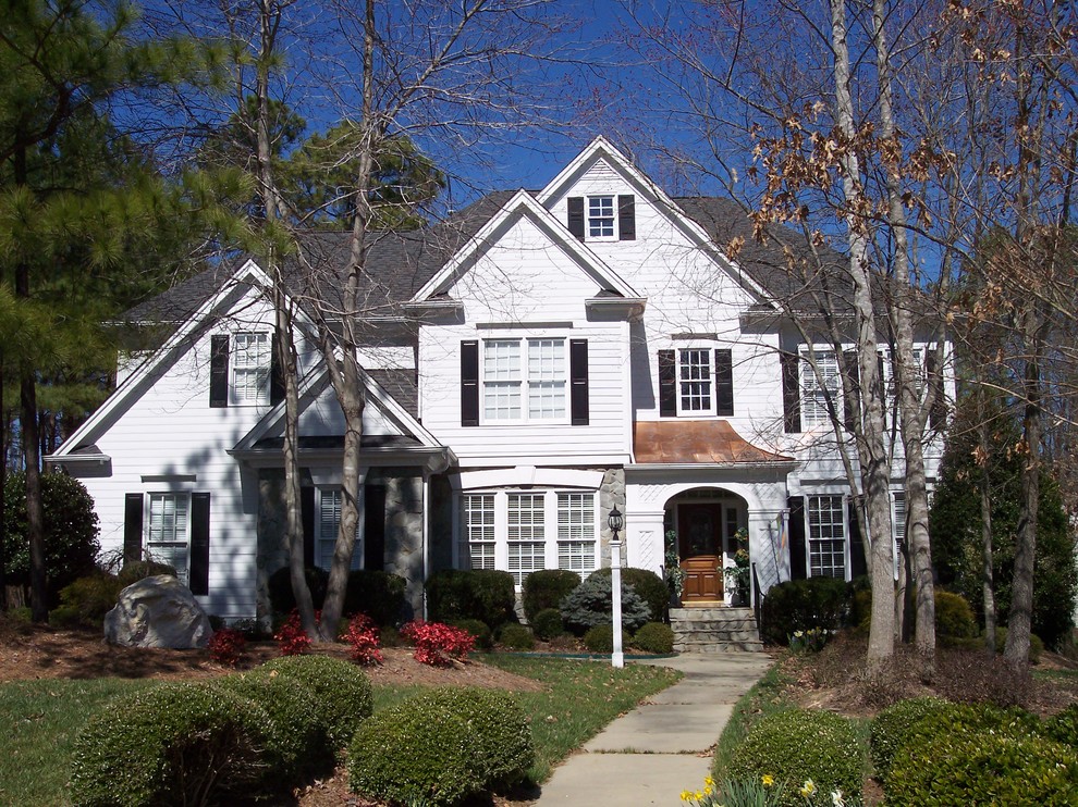 Photo of a large traditional three-storey white exterior in Raleigh with wood siding.