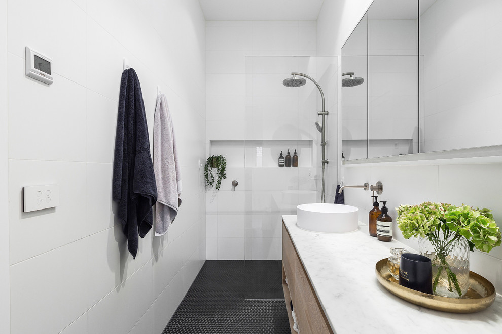 Mid-sized contemporary kids wet room bathroom in Melbourne with light wood cabinets, white tile, porcelain tile, white walls, mosaic tile floors, marble benchtops, black floor, an open shower and white benchtops.