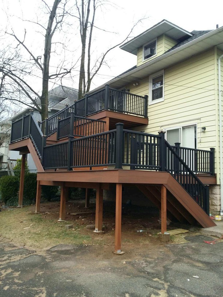 Huge mountain style backyard balcony deck photo in New York with a roof extension