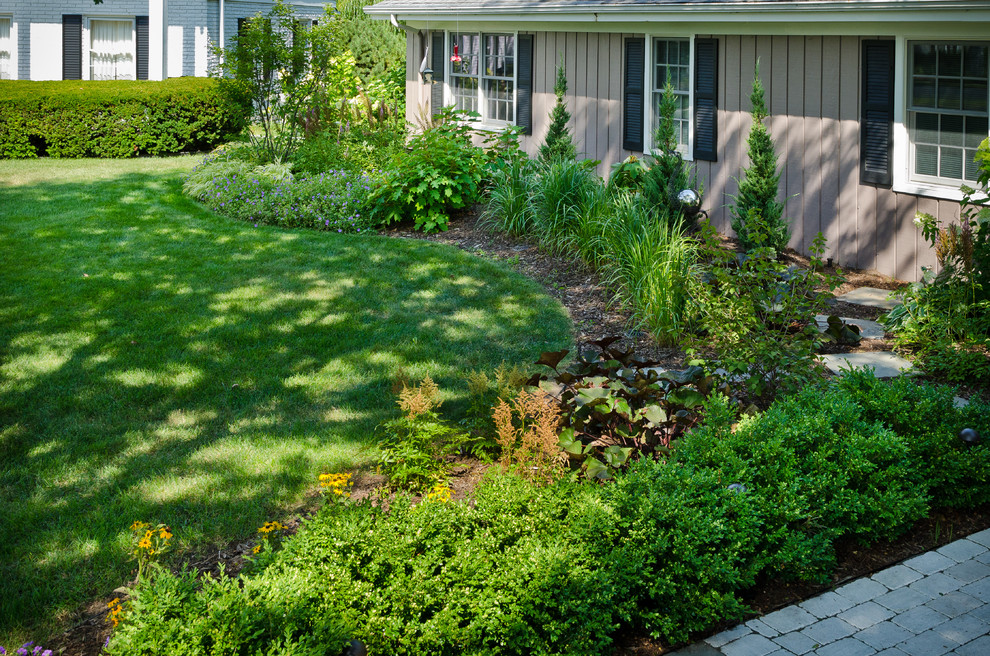 Design ideas for a mid-sized transitional front yard shaded garden for summer in Milwaukee with natural stone pavers.