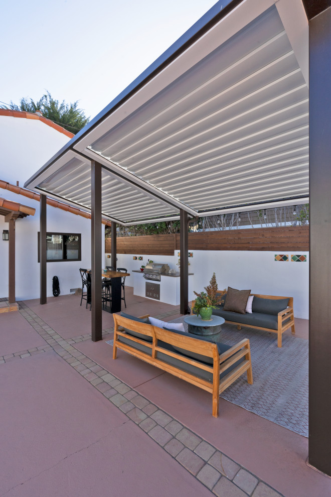 Photo of a mid-sized mediterranean backyard patio in San Luis Obispo with an outdoor kitchen, concrete slab and a pergola.