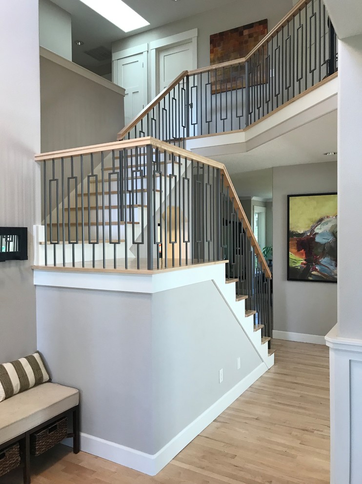 Large modern wood u-shaped staircase in Portland with wood risers and mixed railing.
