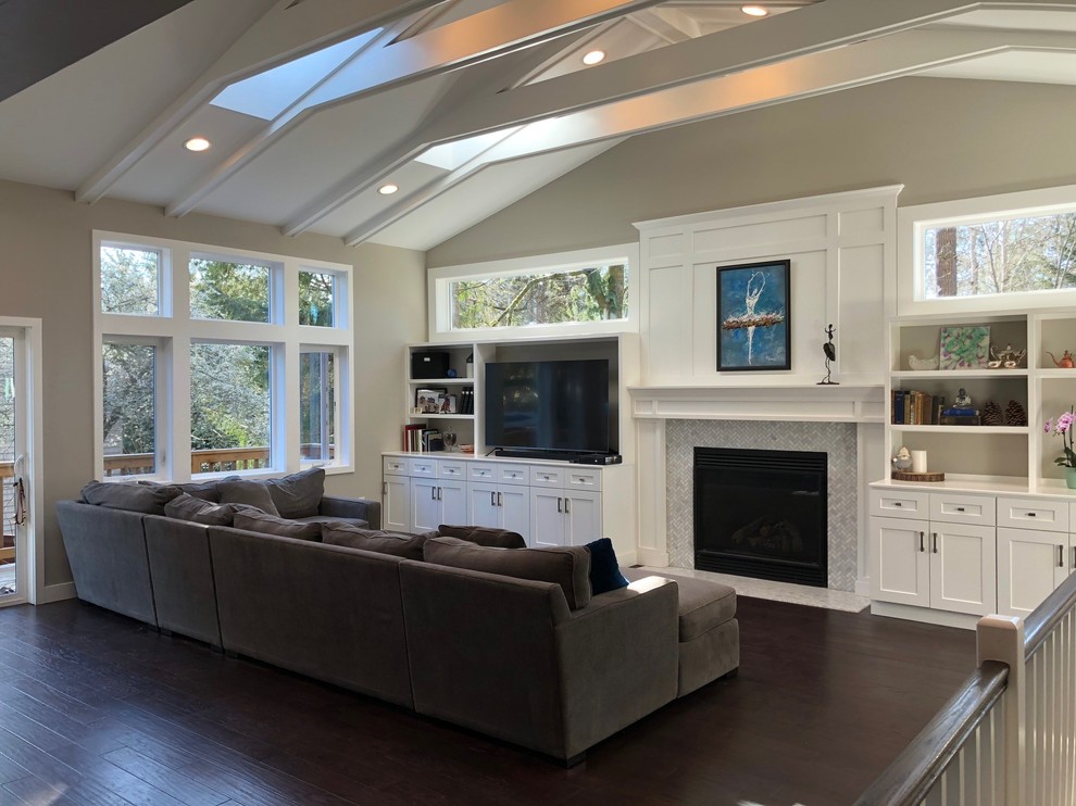 Inspiration for a mid-sized transitional enclosed family room in Seattle with beige walls, dark hardwood floors, a standard fireplace, a tile fireplace surround, a freestanding tv and brown floor.