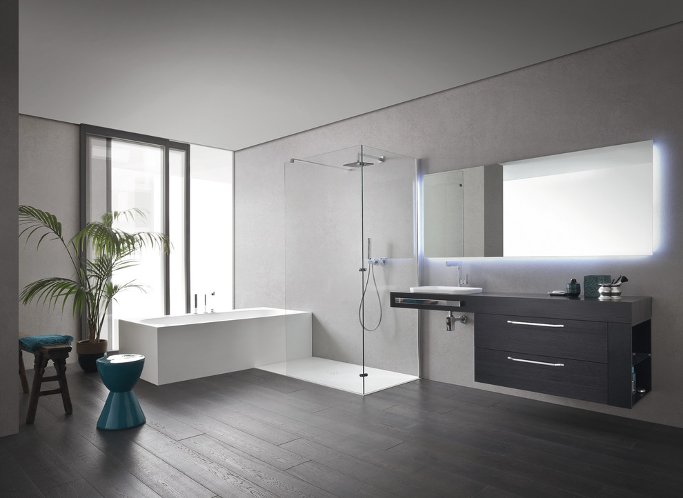 This is an example of a small modern 3/4 bathroom in San Diego with an integrated sink, flat-panel cabinets, dark wood cabinets, a freestanding tub, a corner shower, a one-piece toilet, white tile, ceramic tile, grey walls and ceramic floors.