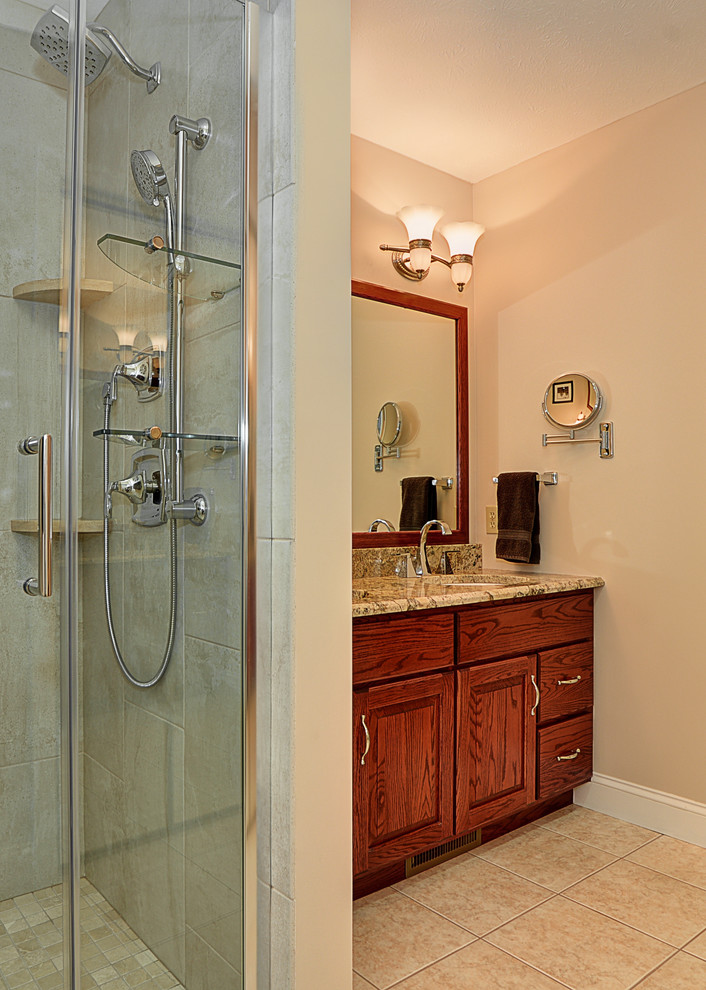 Inspiration for a large transitional master beige tile and ceramic tile ceramic tile corner shower remodel with recessed-panel cabinets, medium tone wood cabinets, beige walls, granite countertops and a two-piece toilet