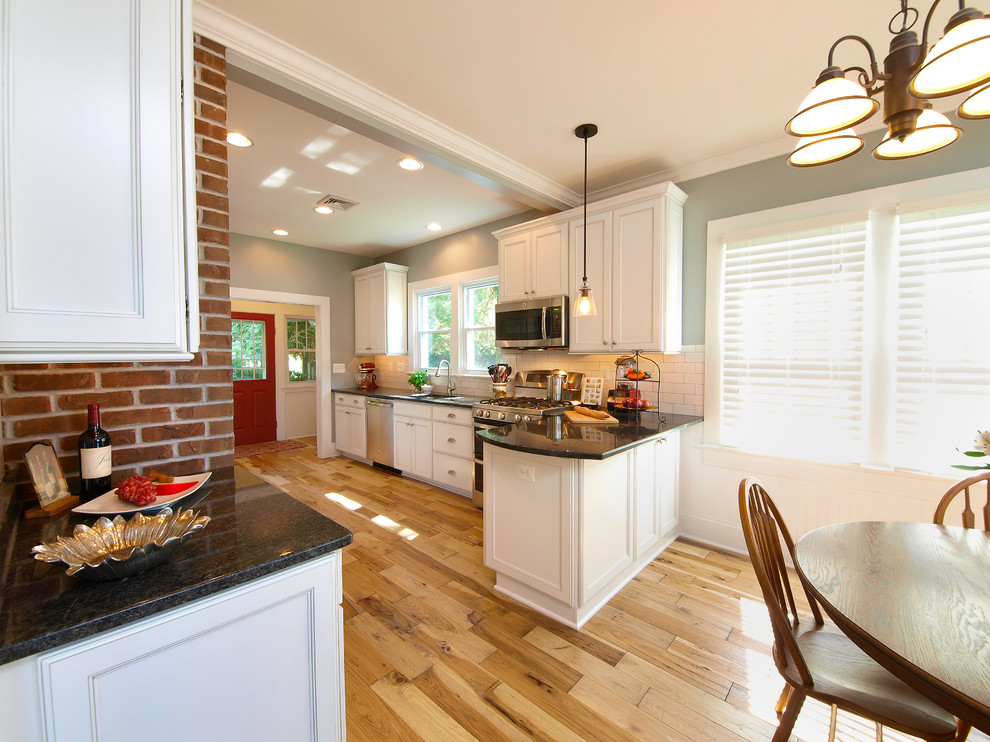 Photo of a traditional kitchen in Baltimore with white cabinets, granite benchtops and medium hardwood floors.