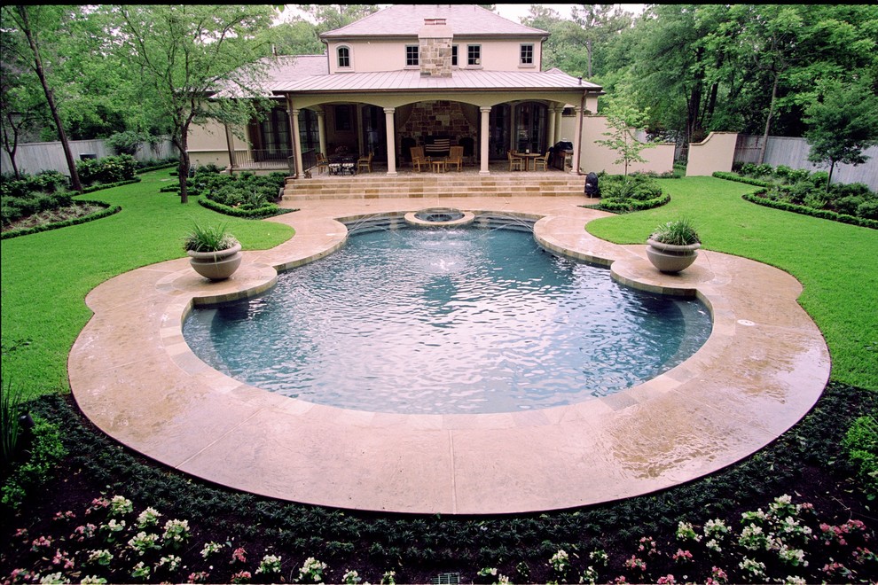 Large traditional backyard custom-shaped pool in Houston with a hot tub and stamped concrete.