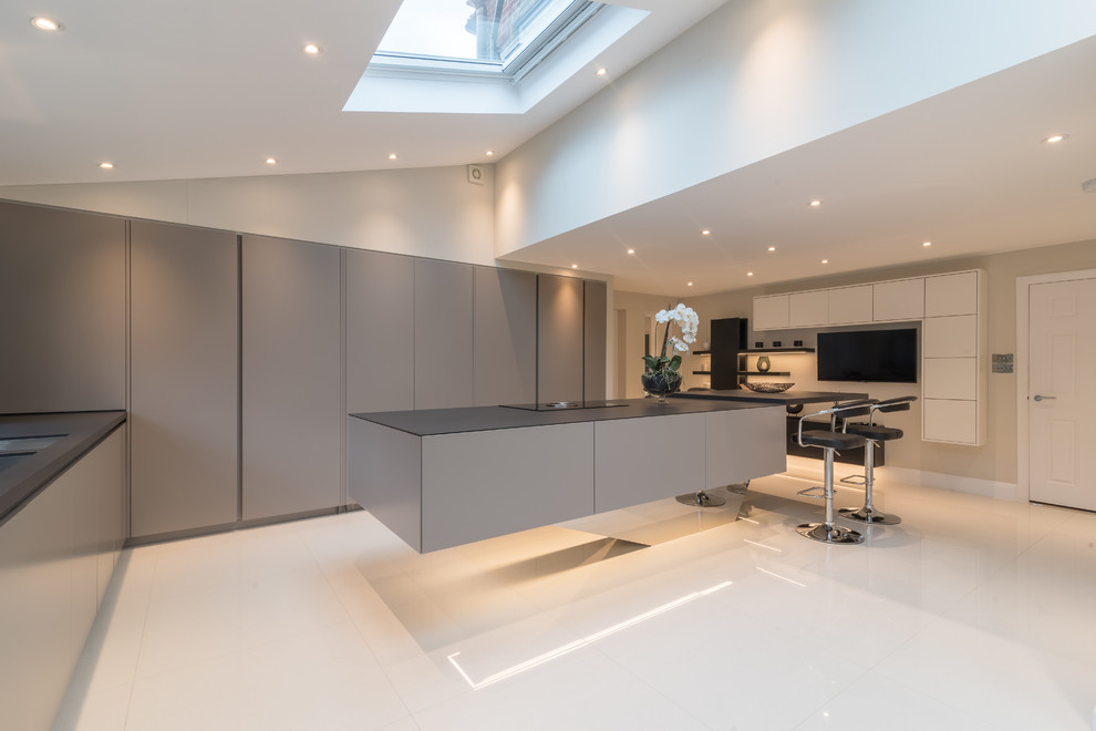 Inspiration for a mid-sized contemporary l-shaped kitchen in Essex with flat-panel cabinets, grey cabinets, with island and white floor.