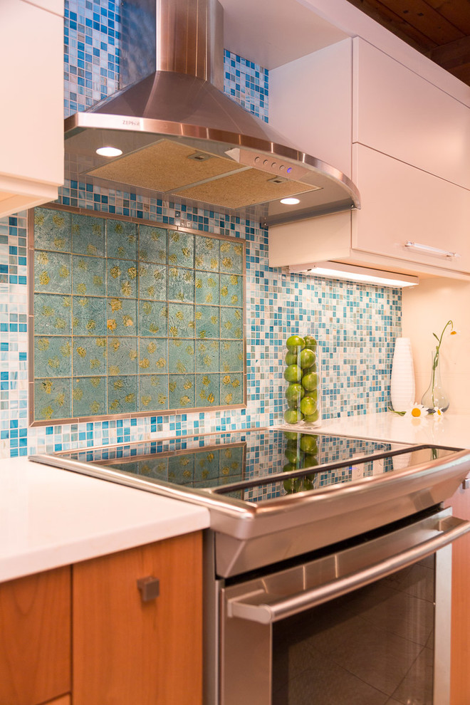 Large tropical galley eat-in kitchen in Boston with a double-bowl sink, flat-panel cabinets, white cabinets, quartz benchtops, blue splashback, glass tile splashback, stainless steel appliances, porcelain floors and with island.