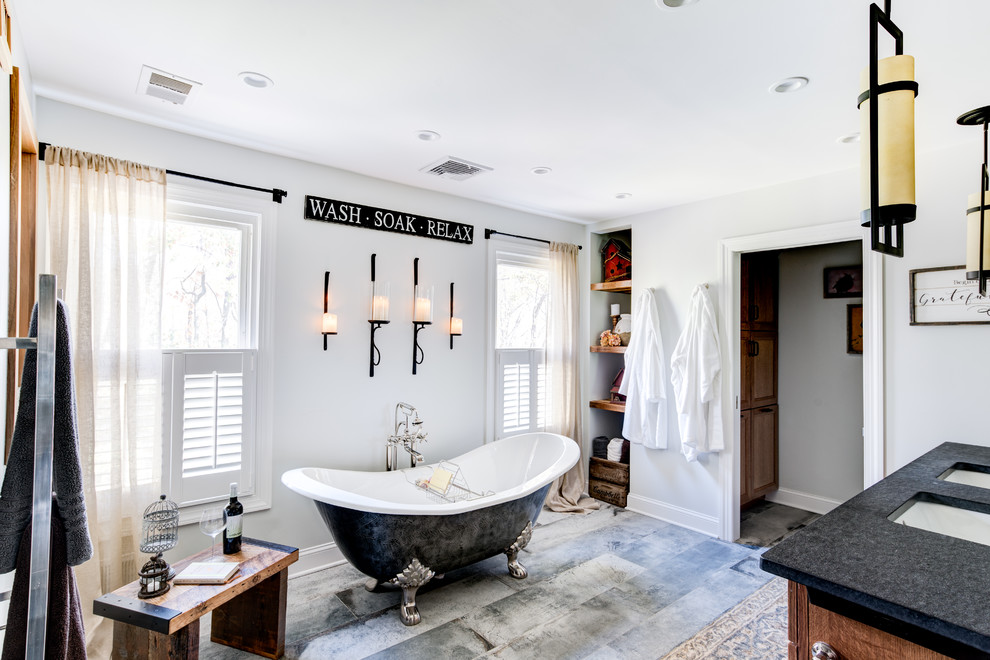 Photo of a large country master bathroom in New York with shaker cabinets, light wood cabinets, an open shower, a one-piece toilet, gray tile, cement tile, grey walls, cement tiles, an undermount sink, granite benchtops, grey floor, a sliding shower screen and a claw-foot tub.
