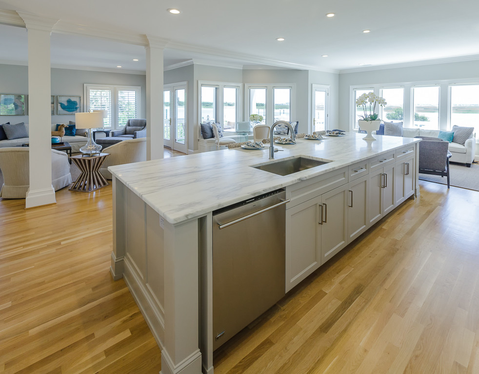 Large transitional galley eat-in kitchen in Wilmington with light hardwood floors, an undermount sink, shaker cabinets, white cabinets, marble benchtops, stone slab splashback, stainless steel appliances and with island.